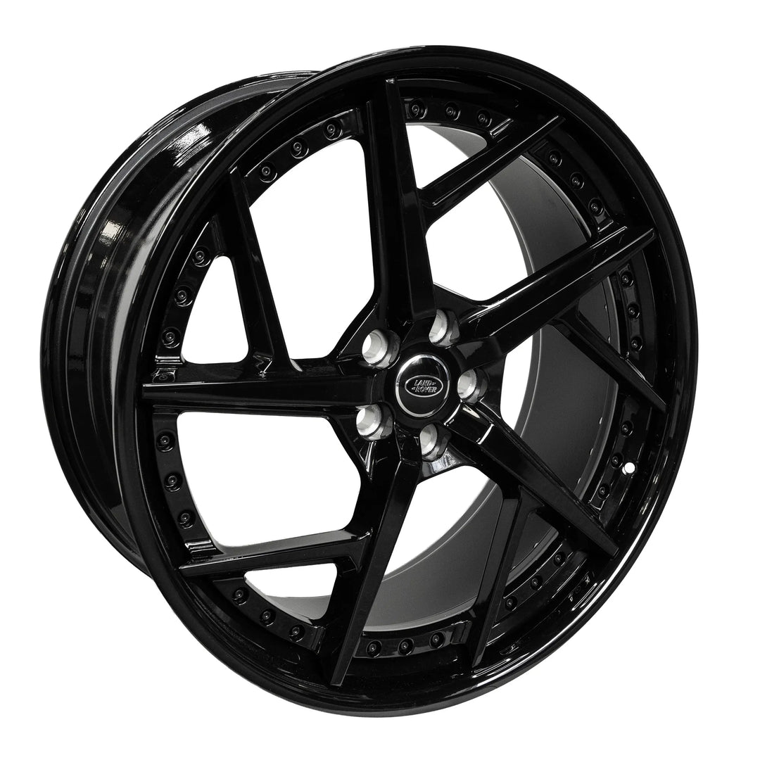 A glossy black Double-spoke alloy wheel rim with a silver center cap and lug nuts, shown at a three-quarter angle on a solid white background.