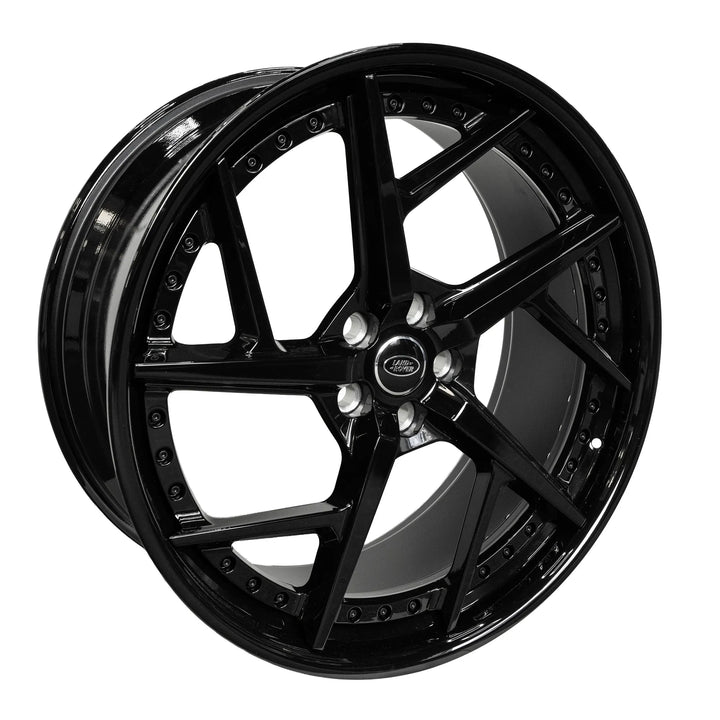 A glossy black Double-spoke alloy wheel rim with a silver center cap and lug nuts, shown at a three-quarter angle on a solid white background.