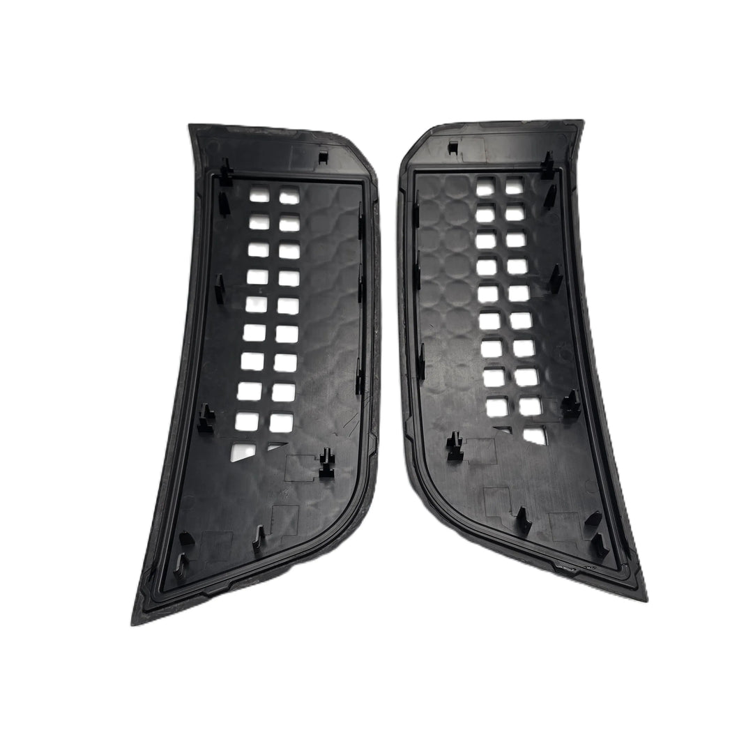 A pair of black plastic automotive side vent trim pieces with a honeycomb pattern and square cutouts, shown on a plain white background.


