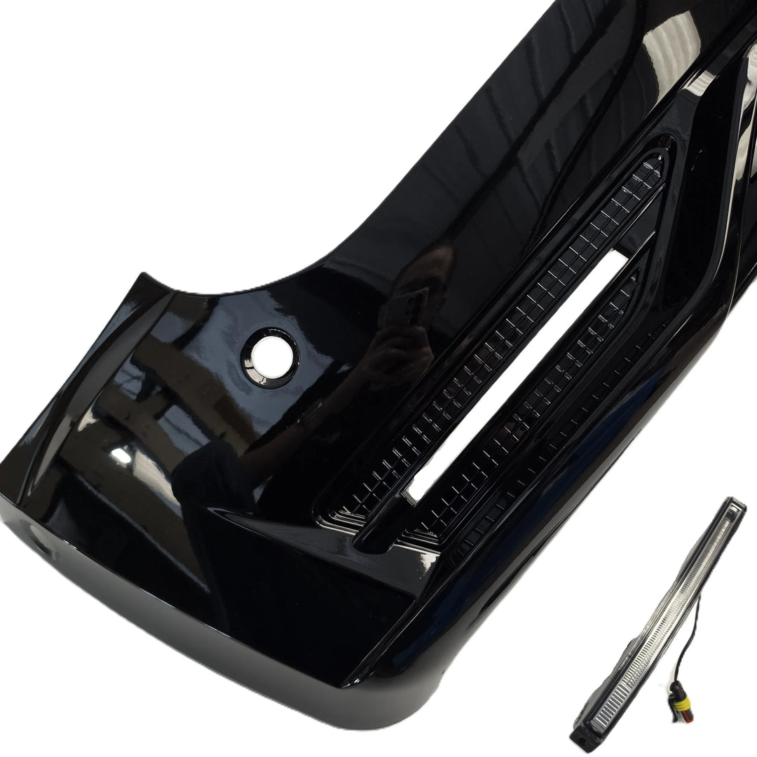 A glossy black car bumper light assembly shown at an angle on a white background, with a small rectangular LED light and wiring connector placed separately in the lower right corner.