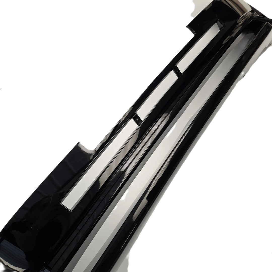 A glossy black automotive bumper trim piece for a defender L663, shown on a plain white background.