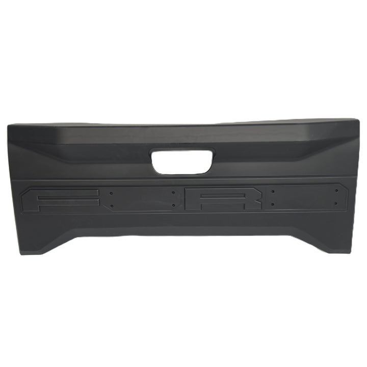 A black plastic rear tailgate cover by sterling automotive with a central cutout for the handle and moulded mounting slots for missing letters, lettering O & D missing from the tailgate cover shown against a plain white background.

