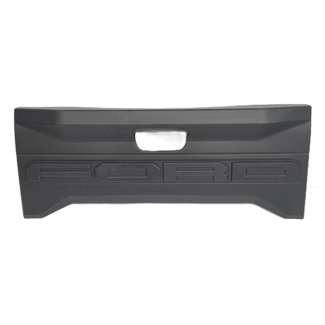 A Rear Ford tailgate black plastic cover or trim piece with a central cutout for tailgate Logo and embossed FORD lettering, shown against a plain white background.
