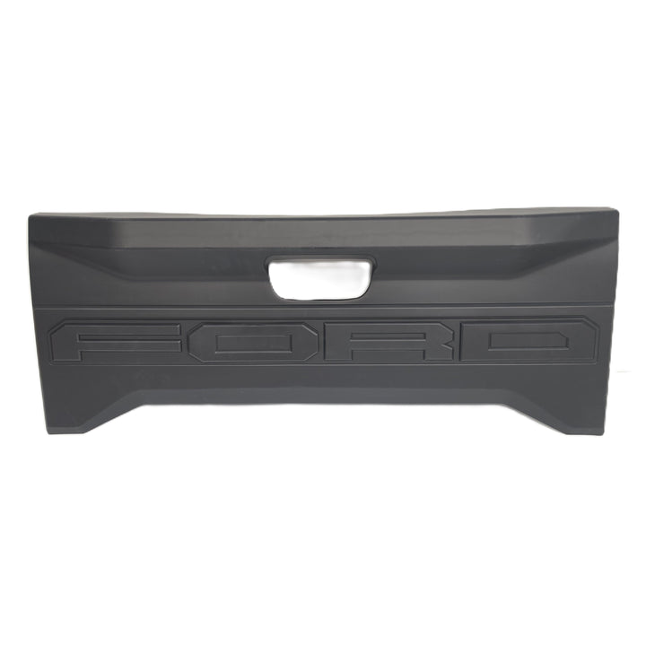 A Rear Ford tailgate black plastic cover or trim piece with a central cutout for tailgate Logo and embossed FORD lettering, shown against a plain white background.