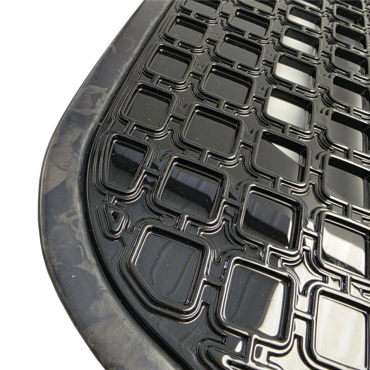 Close Up Shot of a black car side vents with forged carbon surrounds with gloss black grid pattern on a white background
