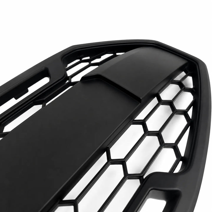 Close-up of a black honeycomb-patterned car grille on a white background