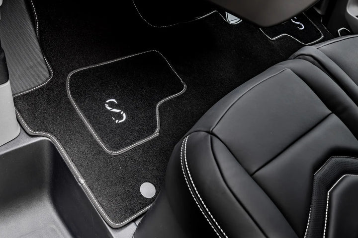Car interior with black floor mats featuring the sterling logo on the driver's side.
