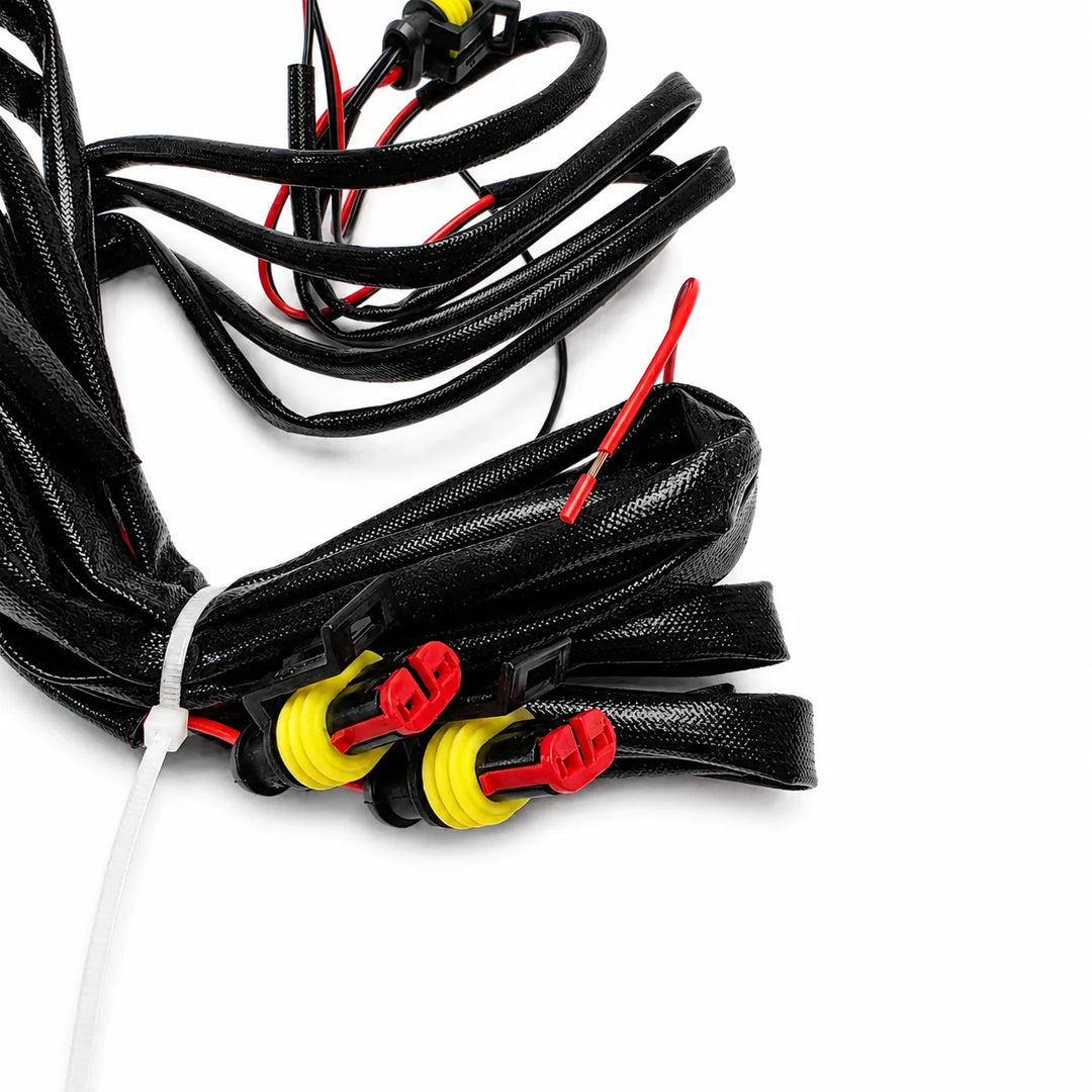 Black textured cable loom with red and yellow connector plugs, bundled with a white zip tie on a white background.