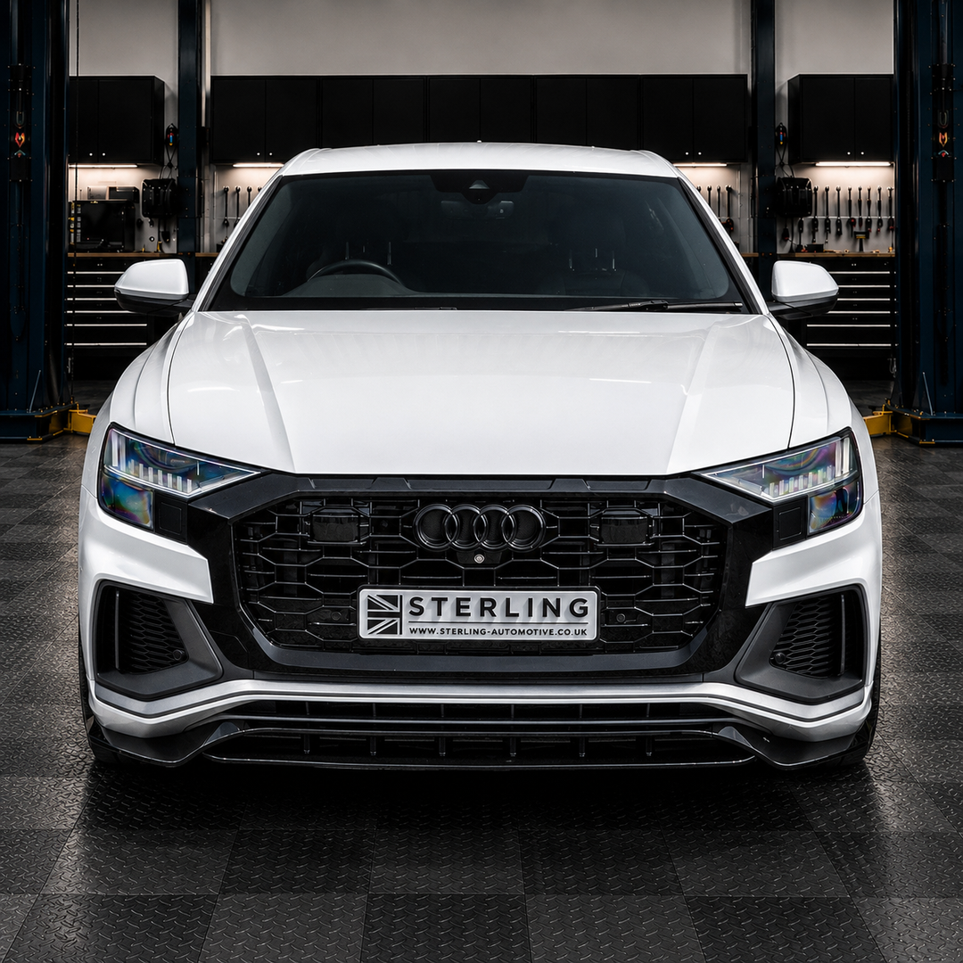 A white Audi Q8 parked facing forward in a garage setting, featuring a custom black front grille with a central license plate that reads 'STERLING' and 'www.sterling-automotive.co.uk.