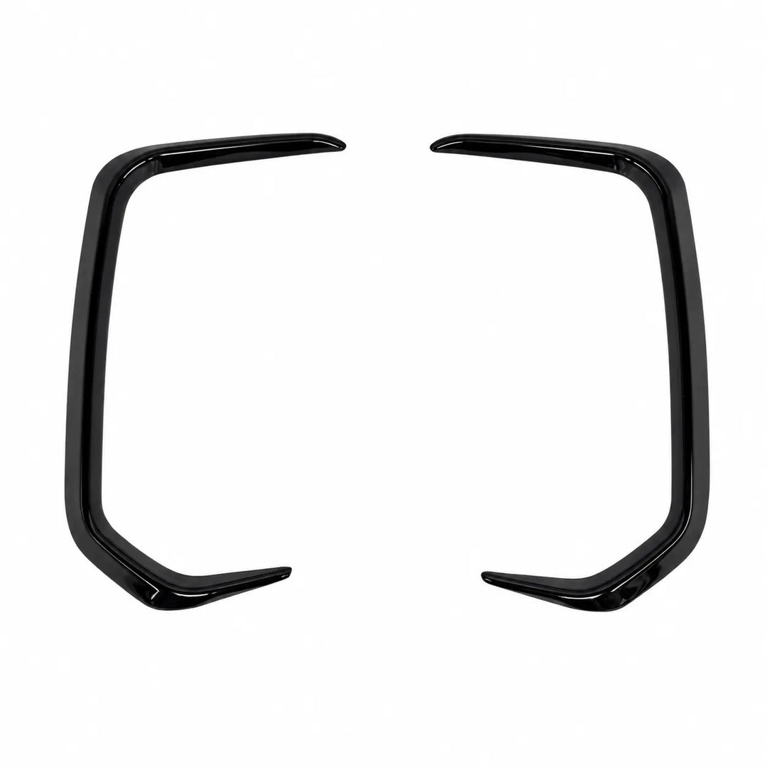 A pair of glossy black curved light surrounds trim pieces, decorative bumper, body trim accents, shown on a plain white background.