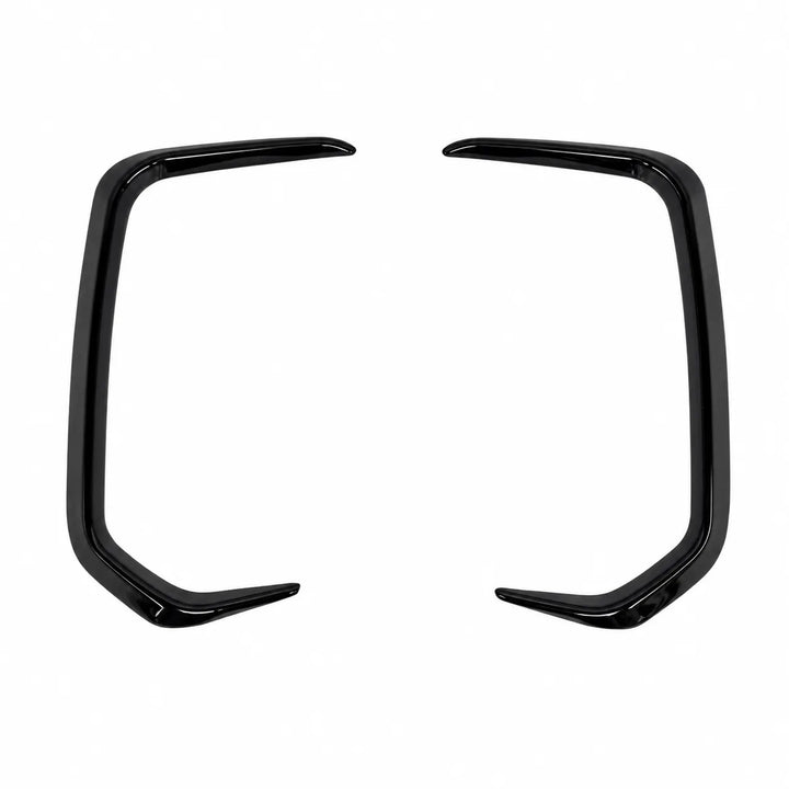 A pair of glossy black curved light surrounds trim pieces, decorative bumper, body trim accents, shown on a plain white background.