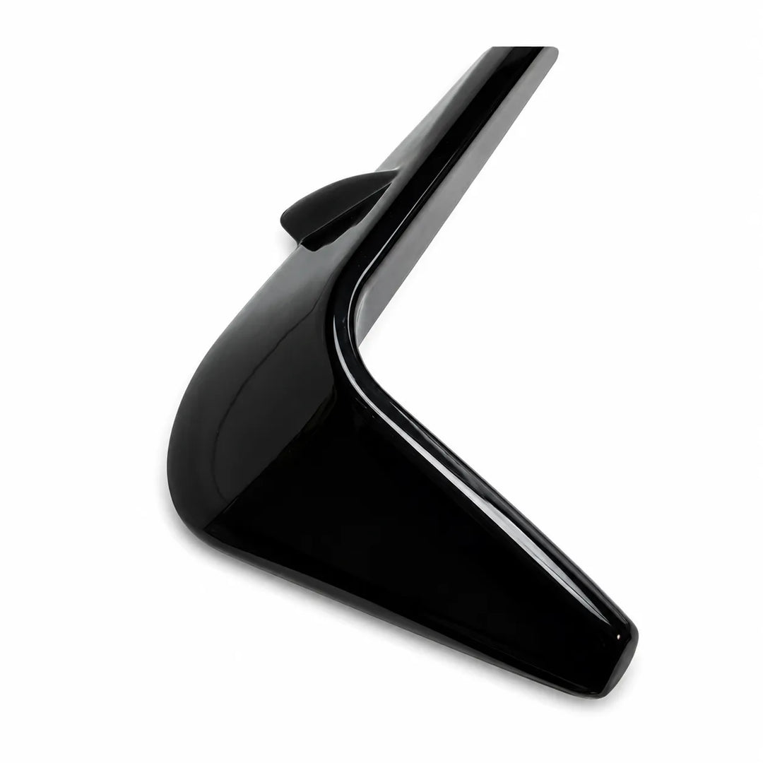 A close-up of a glossy black angular two notch front light fog surrounds winglets above on a white background., shown against a plain white background.