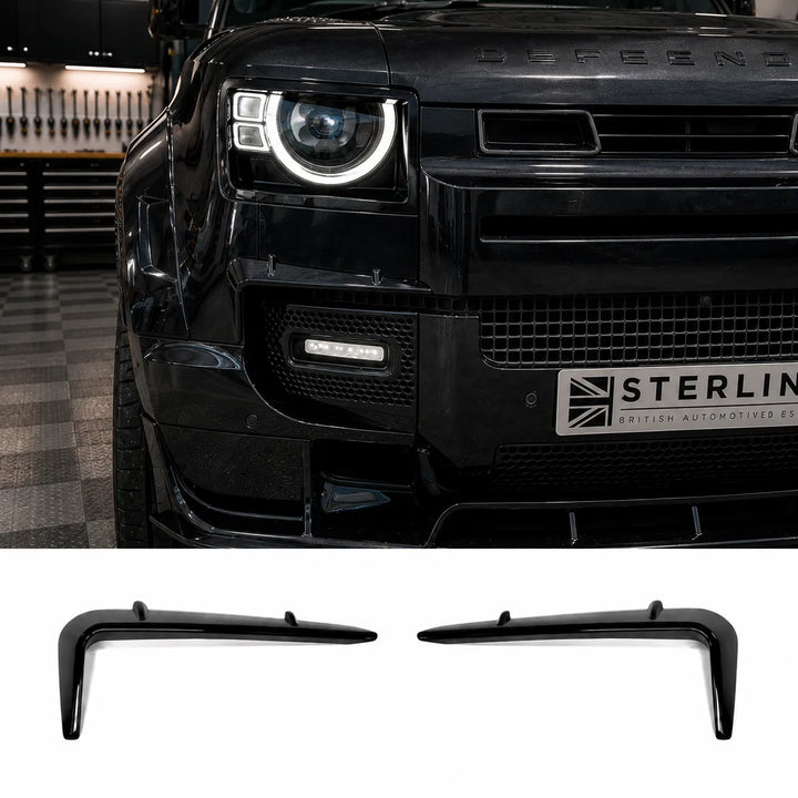 Black angular two notch front light fog surrounds winglets, fitted to a black Land Rover Defender L663 front grille surrounds pair Canard and bumper above on a split background.

