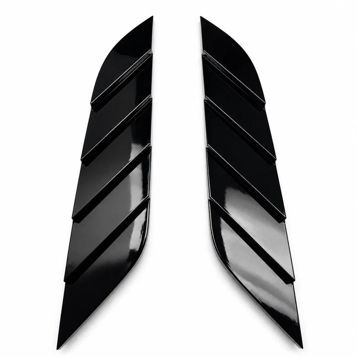 A pair of glossy black Stepped decorative wing-like trim pieces with diagonal layered slits, shown on a plain white background.