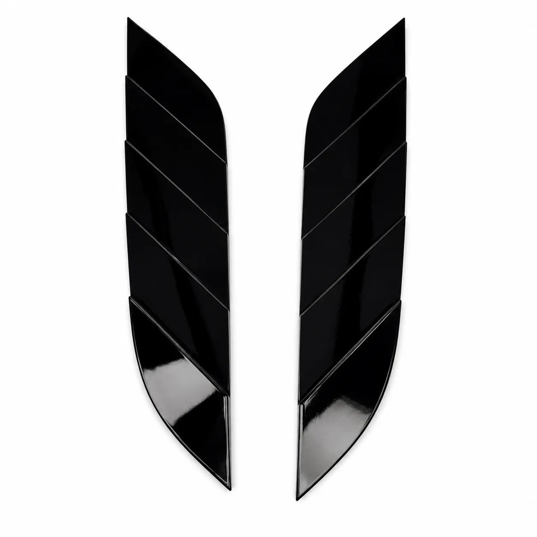 A pair of glossy black, curved wing-shaped trim pieces with a segmented chevron design, displayed on a solid white background.
