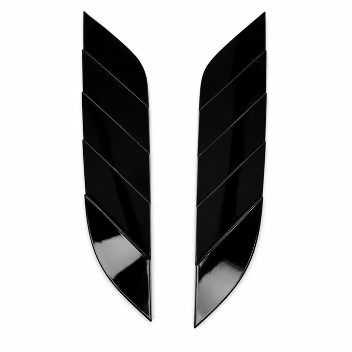A pair of glossy black, curved wing-shaped trim pieces with a segmented chevron design, displayed on a solid white background.