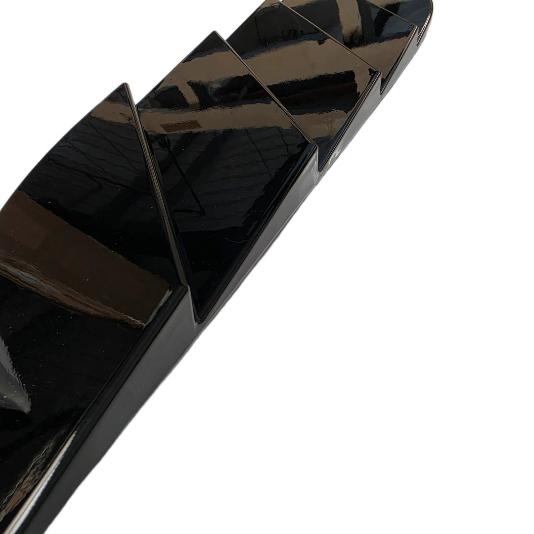 A close-up of a glossy black textured accessory, bonnet trim, shown diagonally on a plain white background.