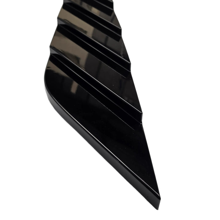 A glossy black plastic or rubber trim piece with a wavy, stepped profile, shown on a plain white background.