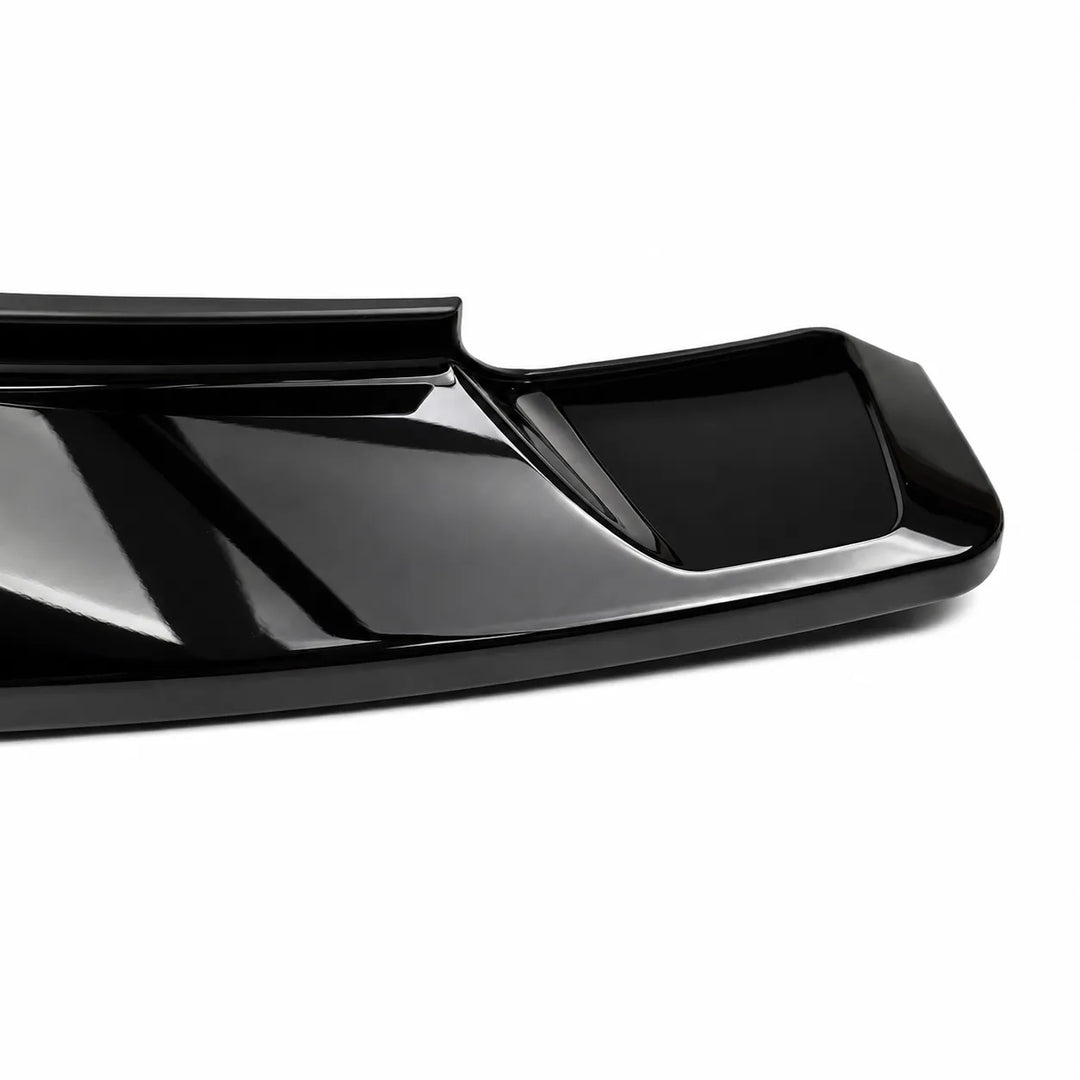 A close-up of a glossy black automotive spoiler or trim piece on a clean white background.