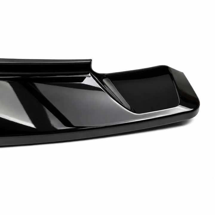 A close-up of a glossy black automotive spoiler or trim piece on a clean white background.