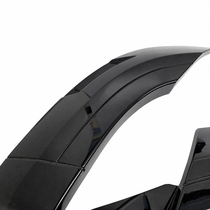 A close-up of a glossy black curved wide arch automotive body panel or fender trim piece against a plain white background.