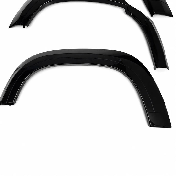 Three glossy black car wheel arches or fender extensions arranged on a plain white background.