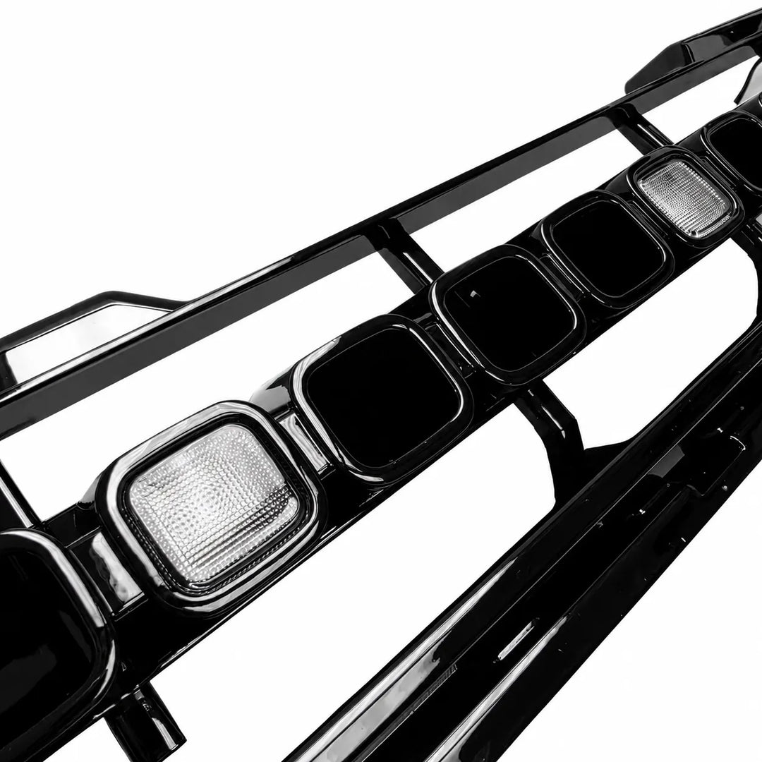 A close-up of a glossy black Defender grille LED Light up accessory, shown on a plain white background.

