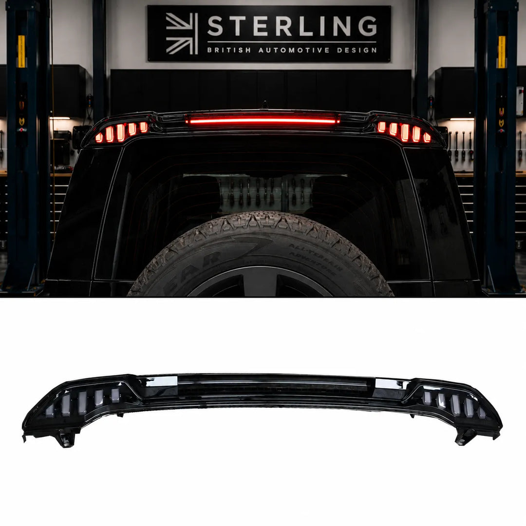 A black automotive rear spoiler with integrated LED light bars, shown both as a standalone product on a white background and installed on the rear of a black land rover defender light spoiler in the sterling garage setting.