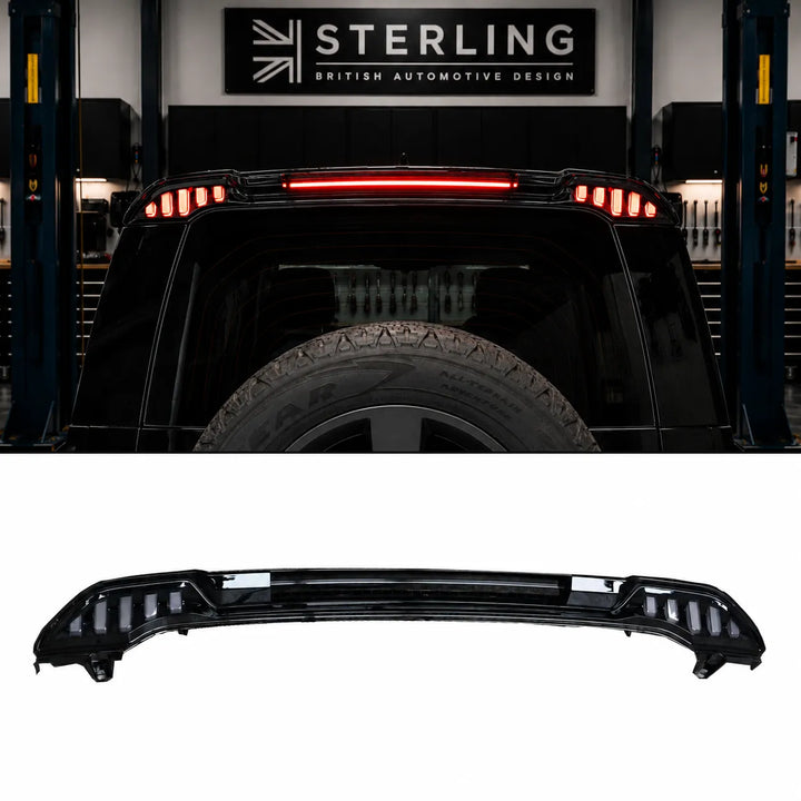 A black automotive rear spoiler with integrated LED light bars, shown both as a standalone product on a white background and installed on the rear of a black land rover defender light spoiler in the sterling garage setting.