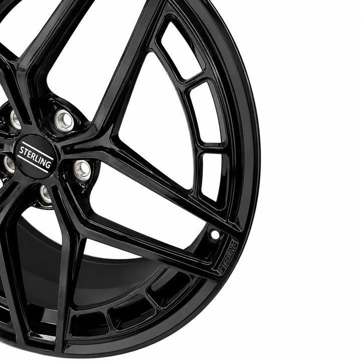 Close-up of a glossy black Sterling alloy wheel rim with a multi-spoke design and silver lug nuts, set against a plain white background.
