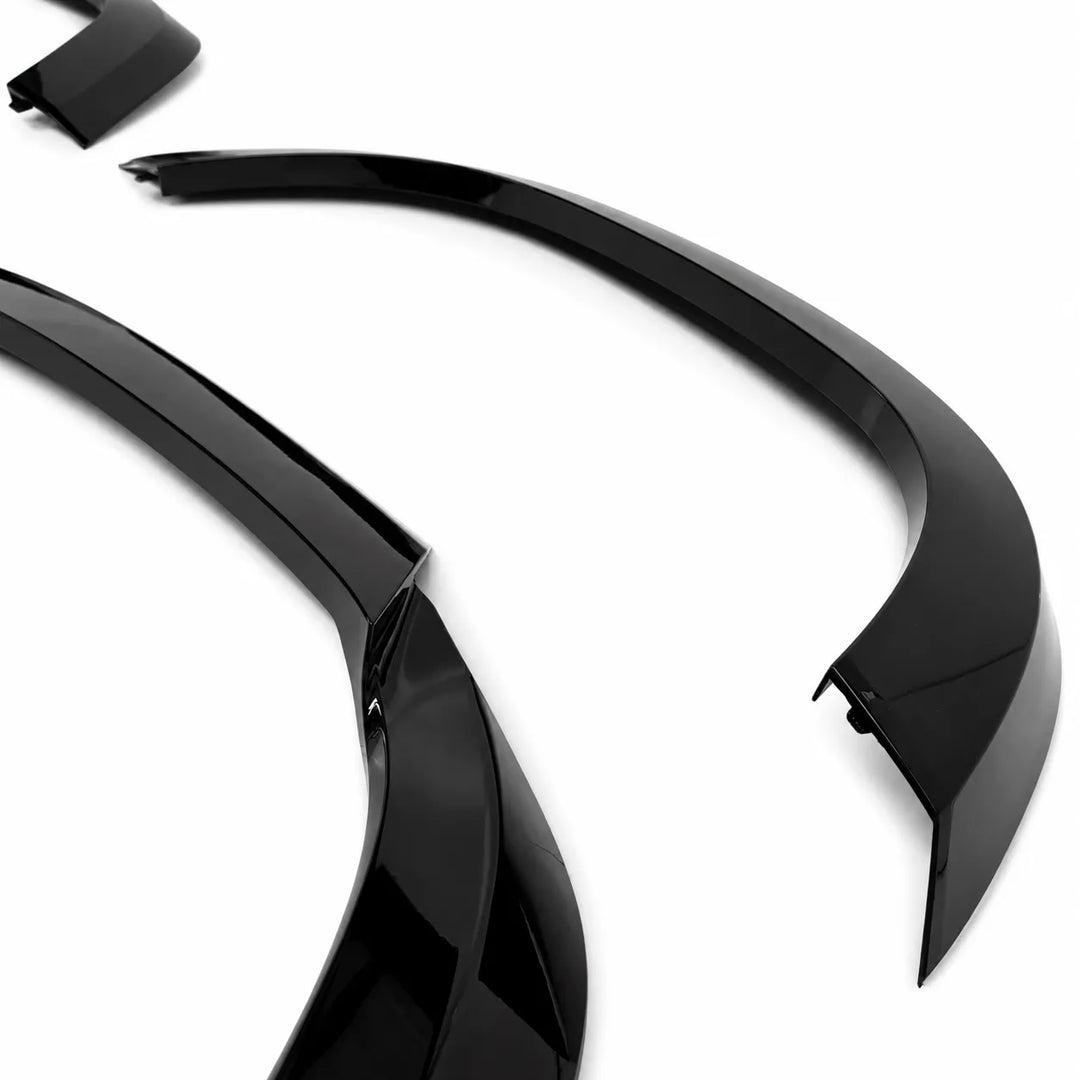 Two plastic Sterling automotive wheel arches fender covers on a plain white background on an angled shot, 3 piece arch set gloss black abs.