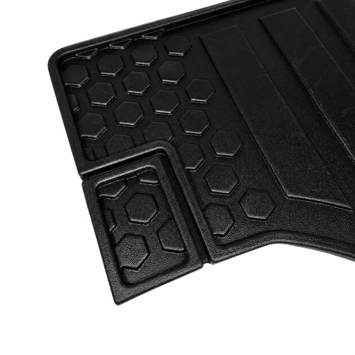Black textured rubber car floor mat with a honeycomb pattern and raised protective trim, shown on a white background.
