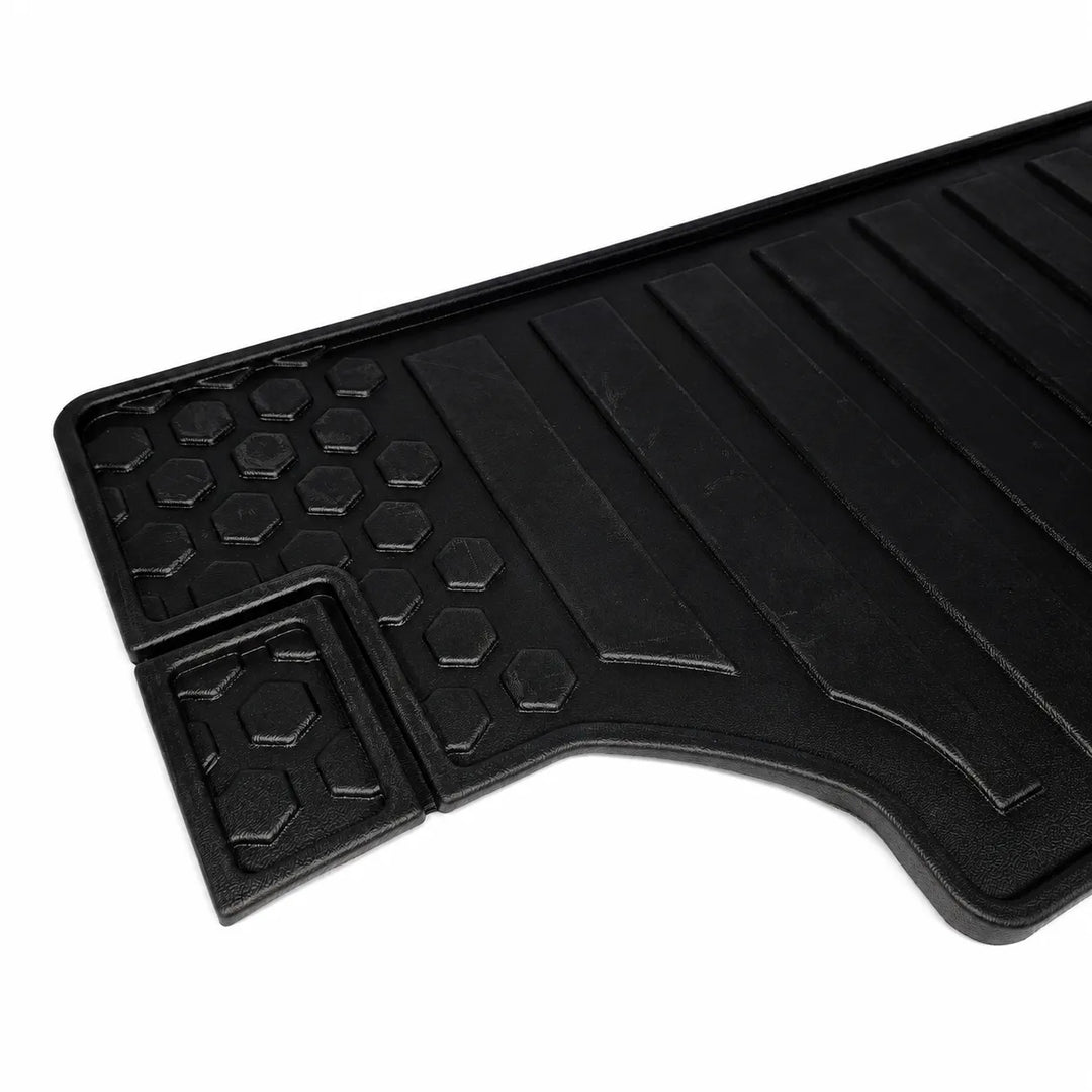 A black rubber car floor mat with a textured honeycomb pattern and raised channel grooves, shown on a plain white background.