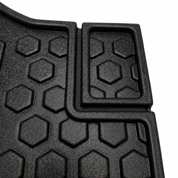 Close-up of a black textured rubber floor mat with a raised hexagonal tread pattern and a rectangular section with a recessed hexagonal design, shown on a white background.