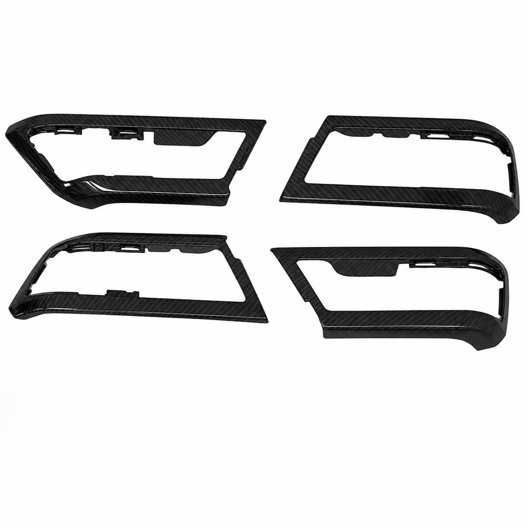 Four black carbon fiber trim pieces arranged in a 2x2 grid on a plain white background.