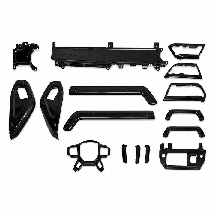 A set of glossy black Carbon trim and body panels for a Defender vehicle, laid out neatly on a solid white background.