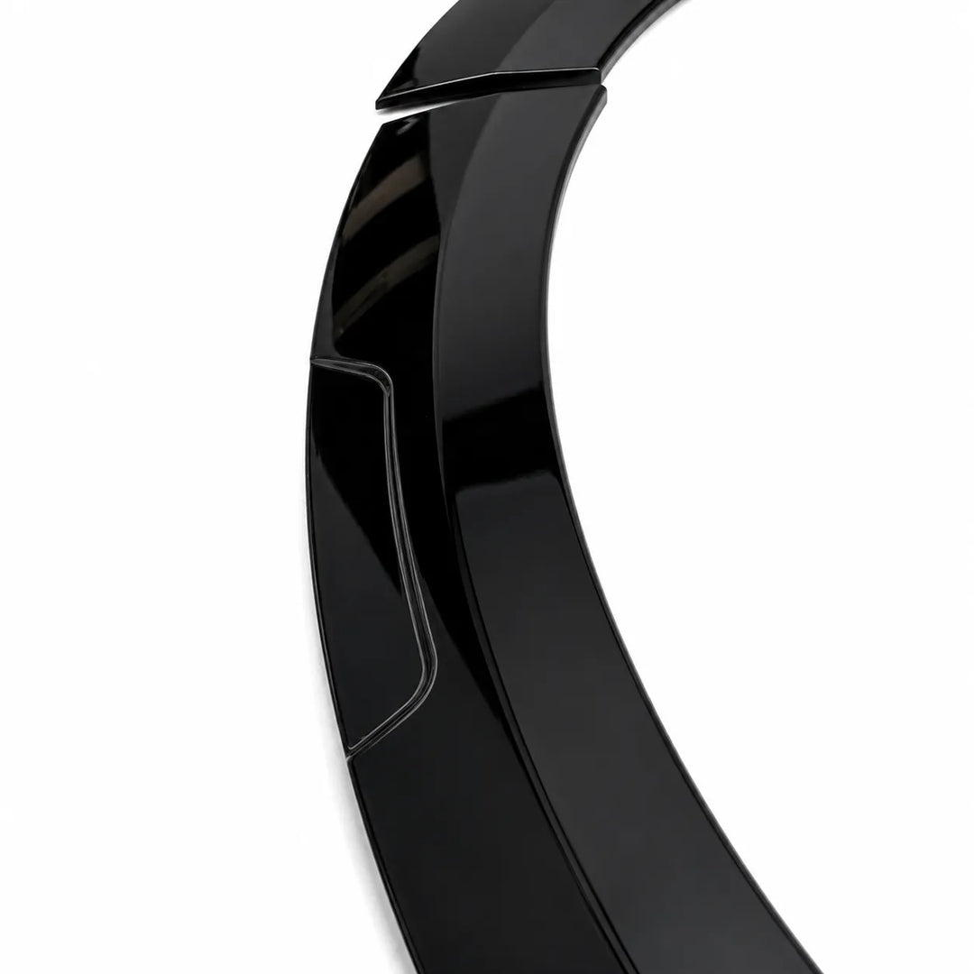 A close-up of a glossy black curved accessory, a wheel arch, shown against a plain white background.