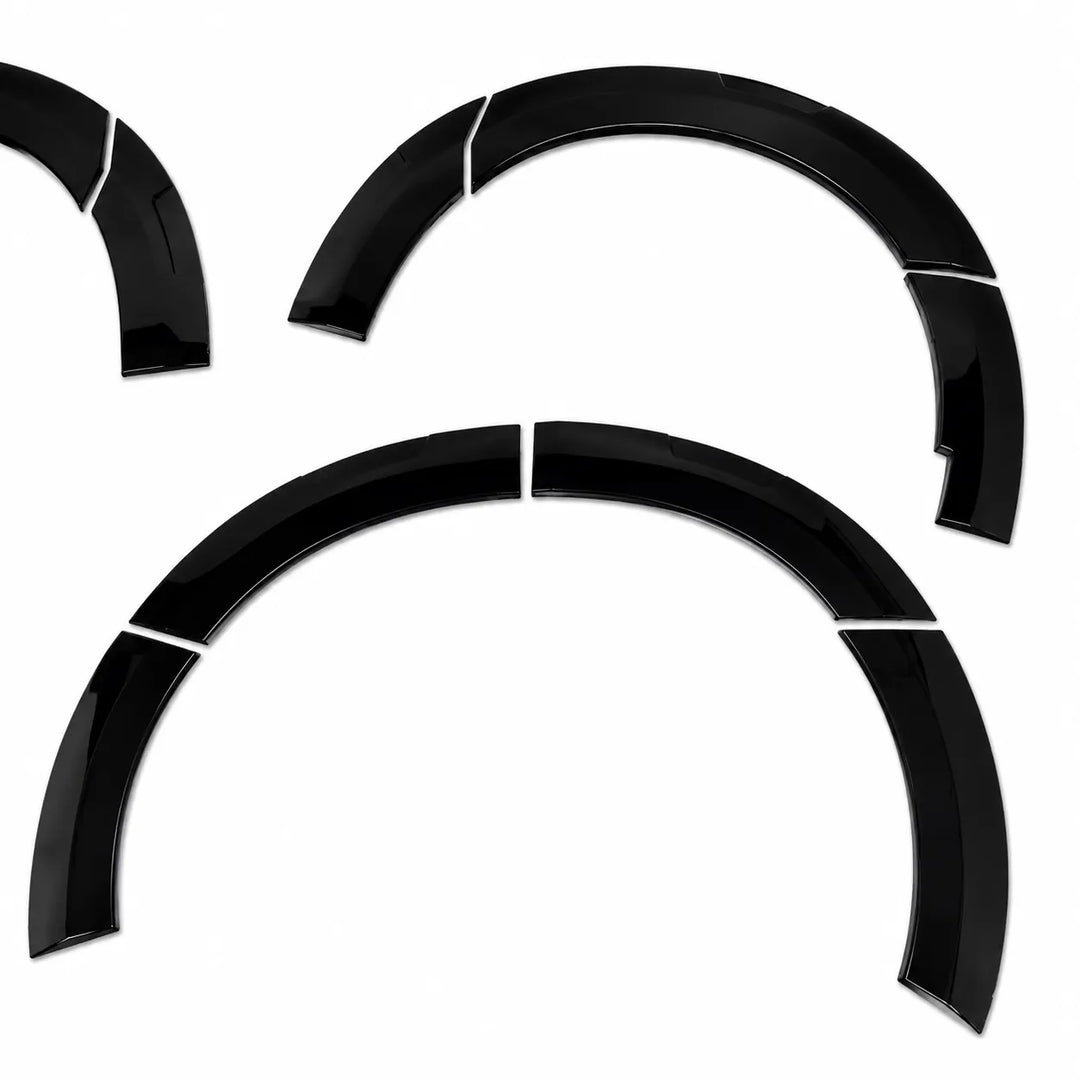 Four glossy black curved automotive wheel arch trim pieces arranged on a plain white background.
