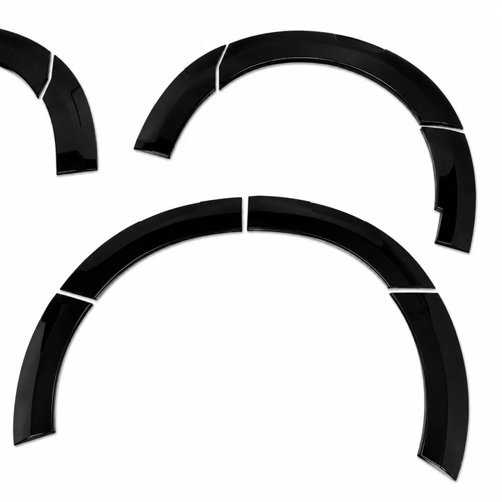 Four glossy black curved automotive wheel arch trim pieces arranged on a plain white background.