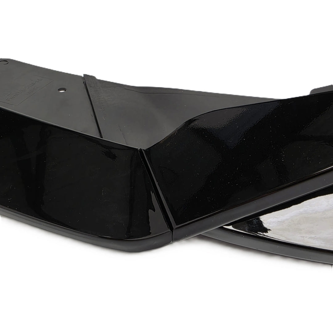 A close-up of a glossy black plastic component, Front Lower Splitter bumper extension lip shown against a plain white background, gloss black 3 piece plastic glossy finish for a tesla model 3 facelift