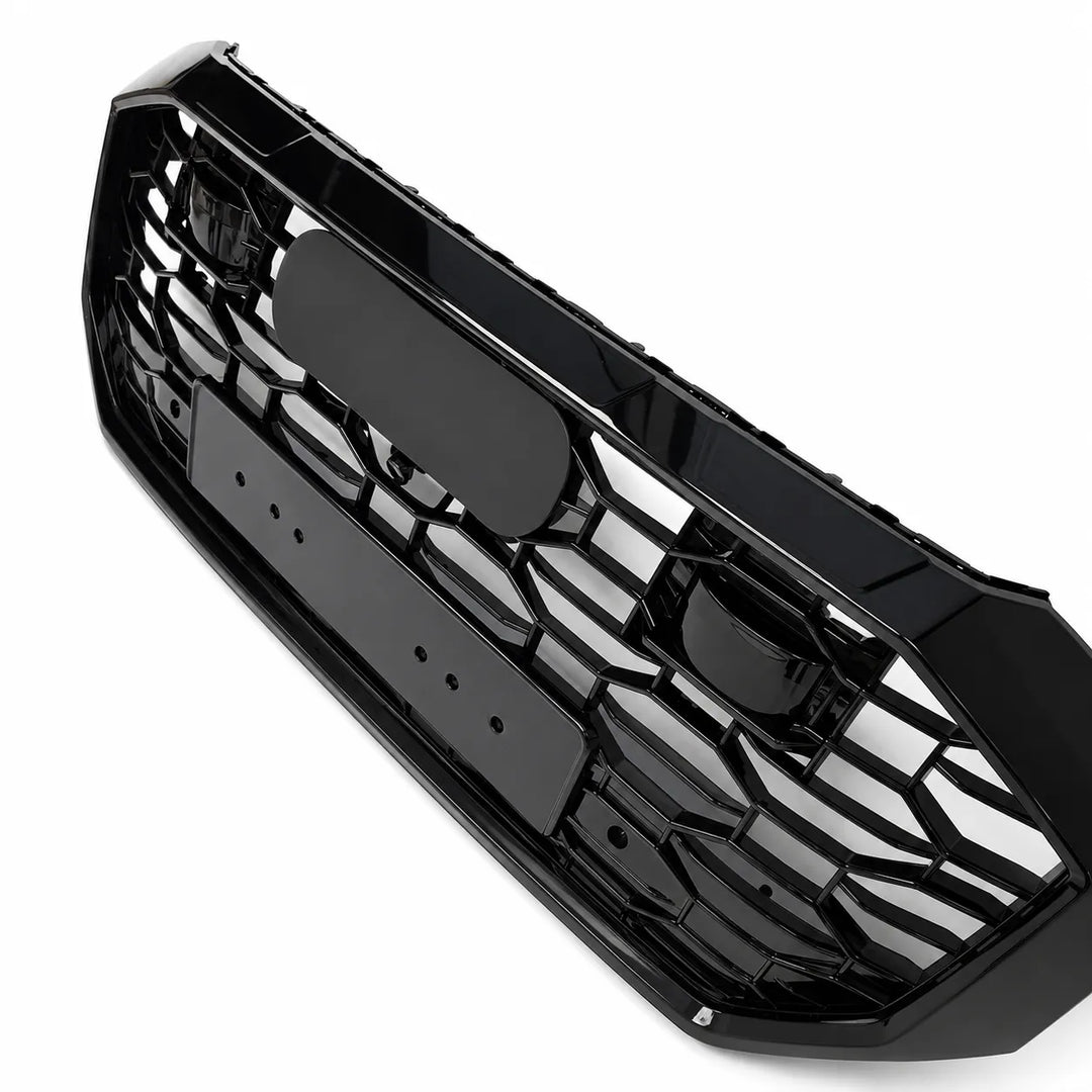 A side shot of black plastic RS Style car grille insert with a honeycomb pattern, shown on a solid white background.