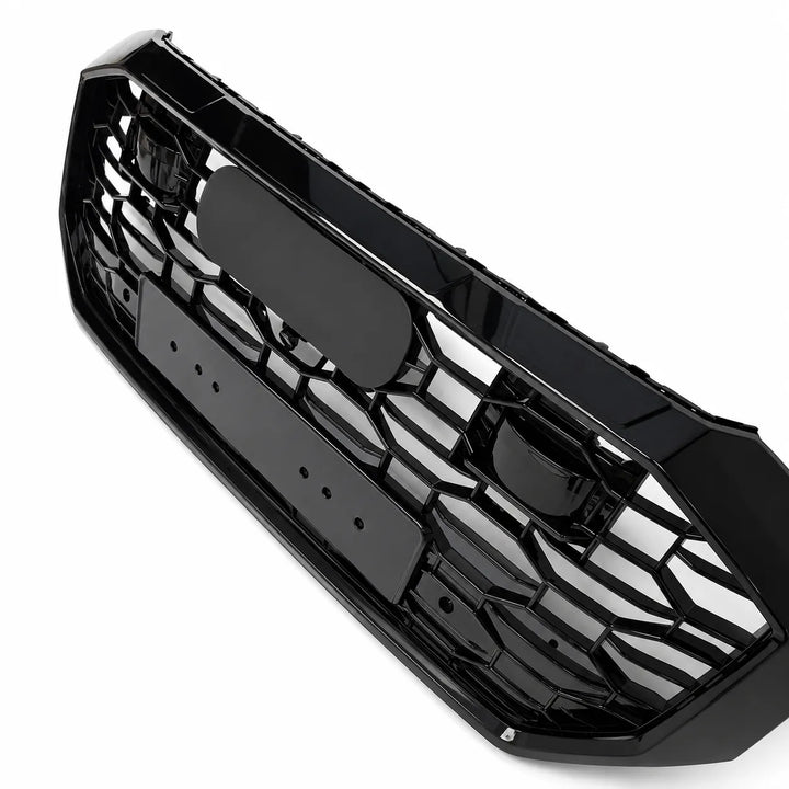 A side shot of black plastic RS Style car grille insert with a honeycomb pattern, shown on a solid white background.