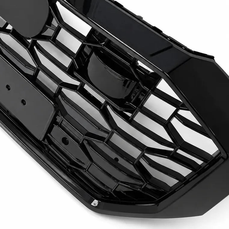 A close up side shot of black plastic RS Style car grille insert with a honeycomb pattern, shown on a solid white background.