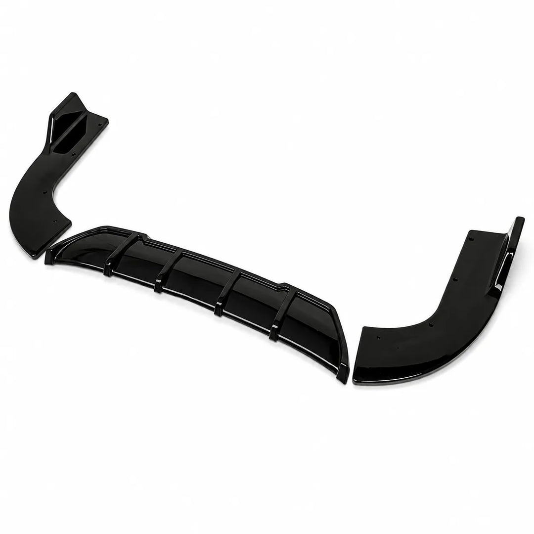 Three glossy black automotive body trim pieces, a rear diffuser or lip kit, arranged diagonally on a plain white background.