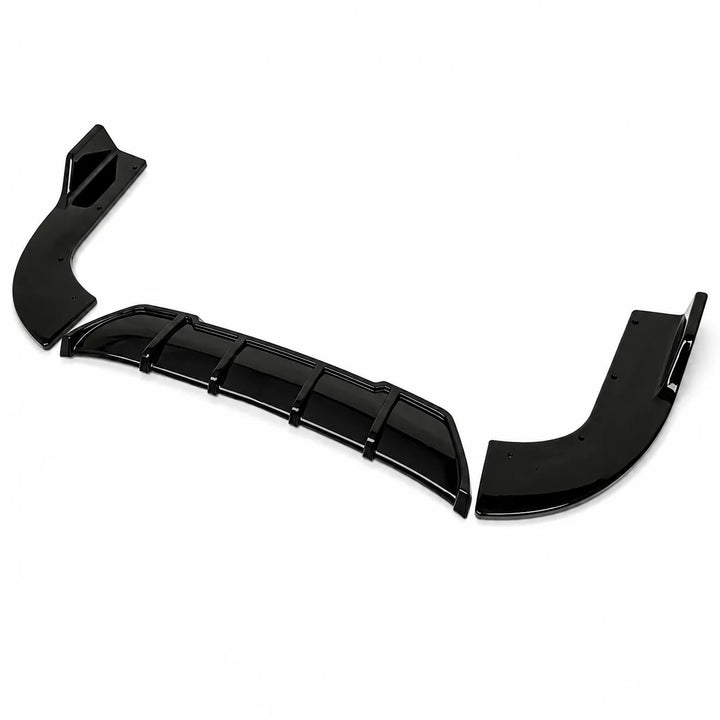 Three glossy black automotive body trim pieces, a rear diffuser or lip kit, arranged diagonally on a plain white background.