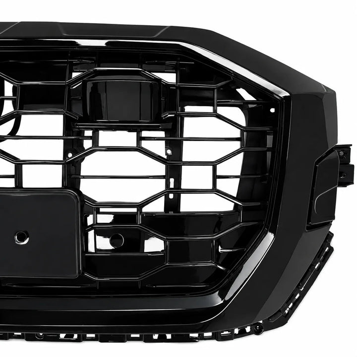 A glossy black front grille with a honeycomb pattern, shown from a three-quarters angle against a white background.