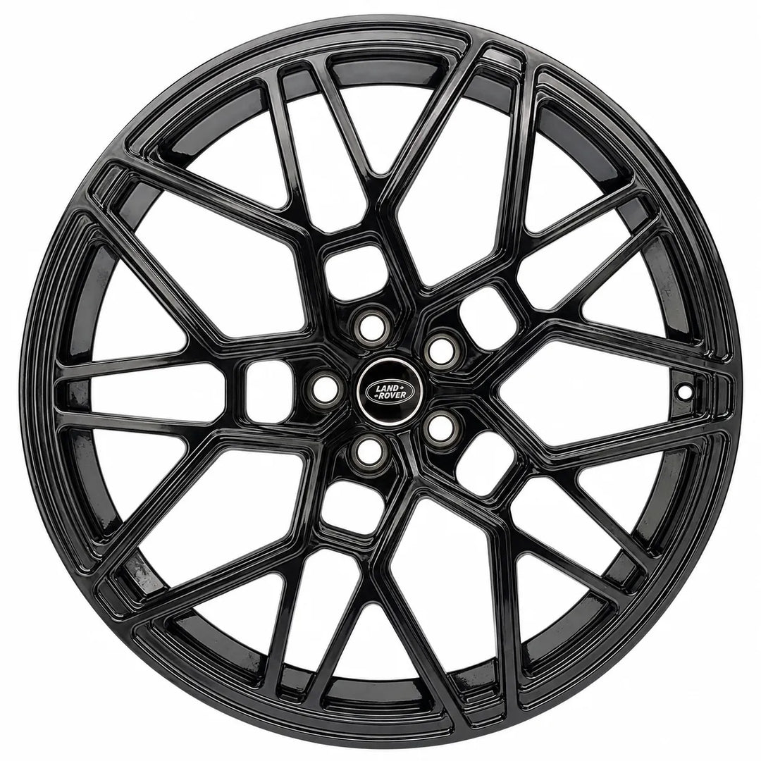 A glossy black multi-spoke alloy wheel rim with a central Land Rover badge, shown against a plain white background.