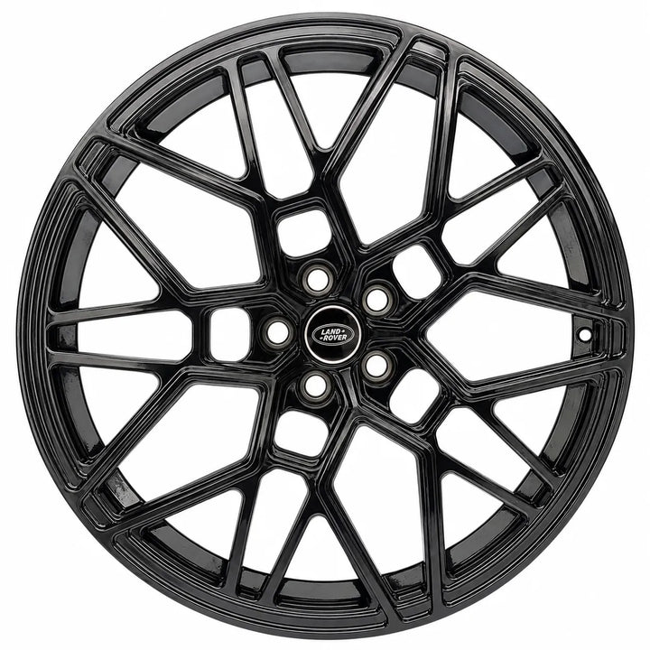 A glossy black multi-spoke alloy wheel rim with a central Land Rover badge, shown against a plain white background.