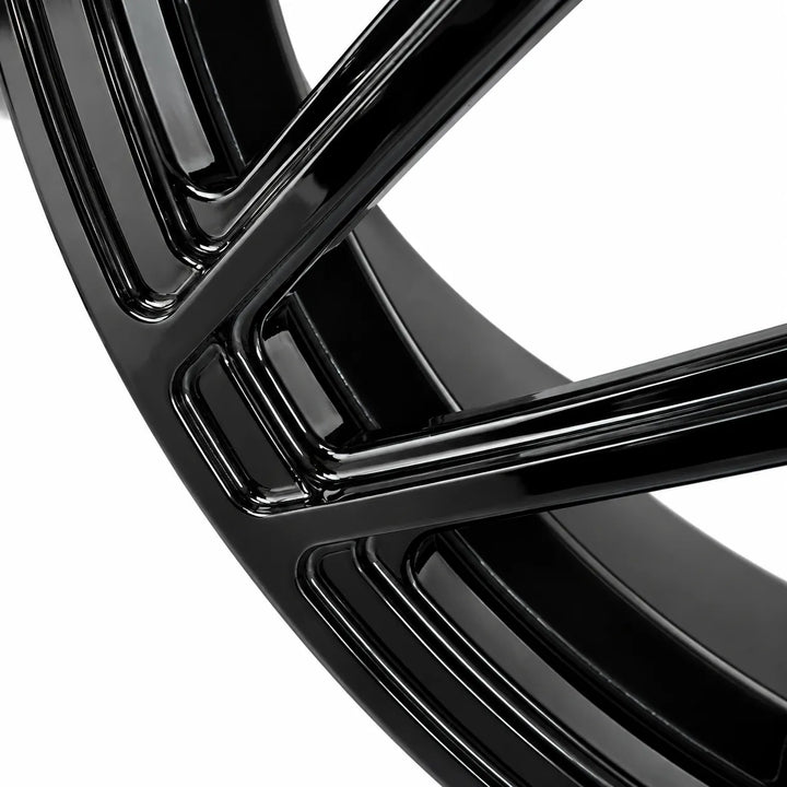 Close-up of a glossy black multi-spoke wheel rim against a solid white background.