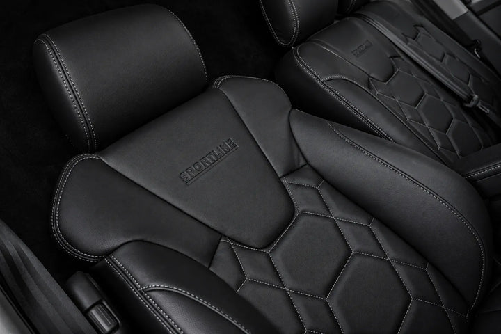 Close-up of black leather car seats with diamond-quilted stitching and embossed SPORTLINE branding on the headrests.